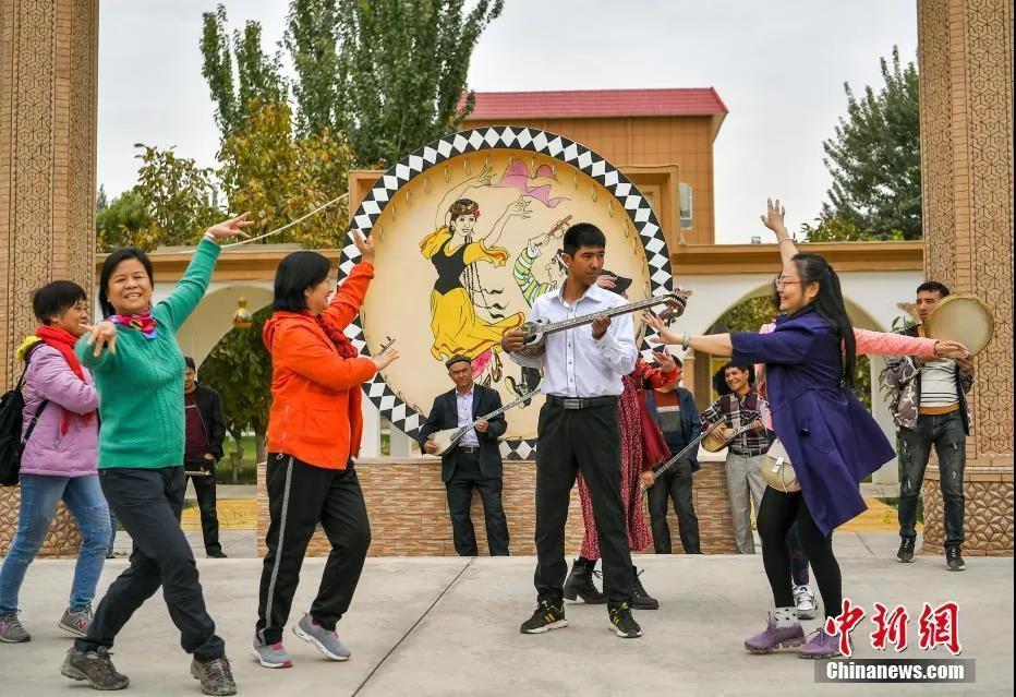 图为新疆疏附县吐万克吾库沙克村的乐器制作艺人们聚在一起,为游客